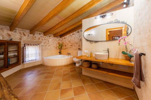 a bathroom with a tub and a sink and a mirror at Finca Fonoll in Santa Margalida