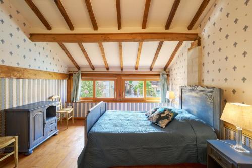 a bedroom with a bed and a tv in a room at Chambres d'hôtes Le Pré Fleuri in Saint-Sulpice-de-Roumagnac