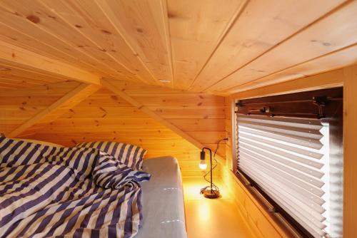 a bed in a small room with a window at Tiny House Ernesto in Lehnin