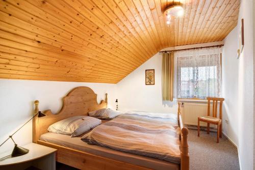 a bedroom with a bed with a wooden ceiling at Haus Bross in Hayingen