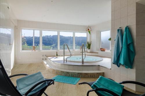 a bathroom with a tub and two chairs in a room at Ferienparadies Bodensee Fewo2 in Billafingen