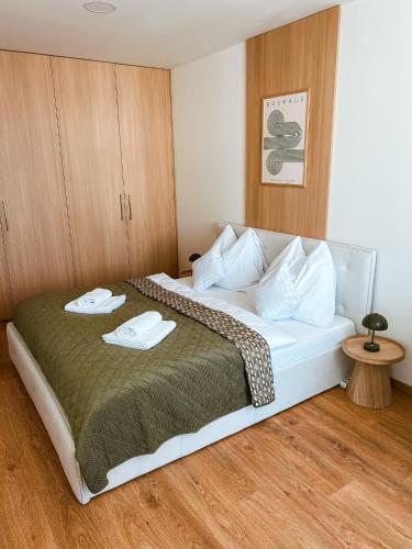 a bedroom with a bed with two towels on it at Bloom Olive Apartment in Trenčín