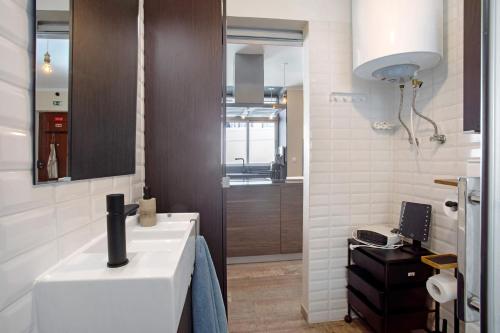 a bathroom with a white sink and a mirror at Home Away From Home in Peniche