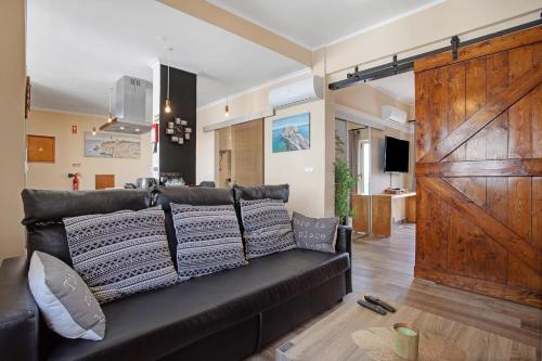 a living room with a black couch and a wooden door at Home Away From Home in Peniche