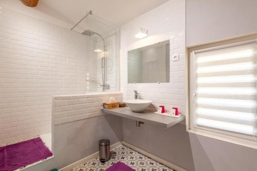 a white bathroom with a sink and a mirror at Gîte Durance Mallemort in Mallemort