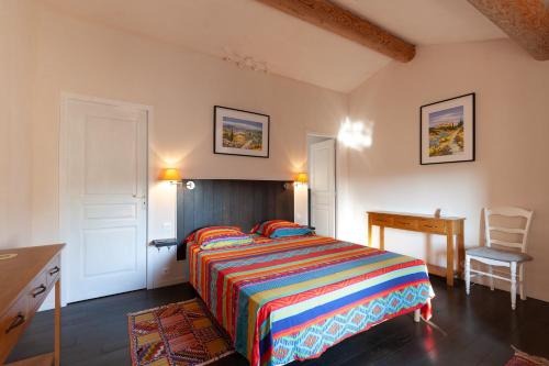 a bedroom with a bed and a desk and a chair at Gîte Durance Mallemort in Mallemort