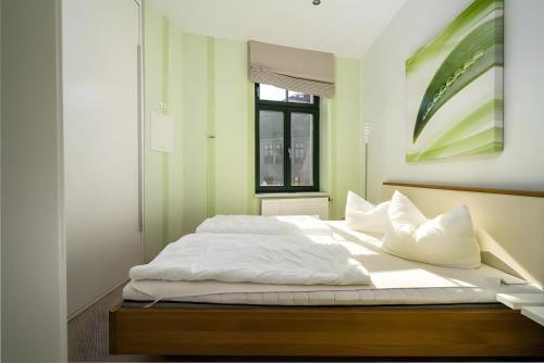 a bedroom with a bed with white sheets and a window at Haus Seezeit in Malchow