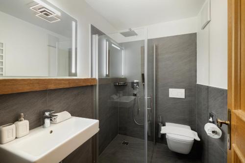 a bathroom with a sink and a toilet and a shower at Vernalhof Apt Sunnaseit in Sluderno