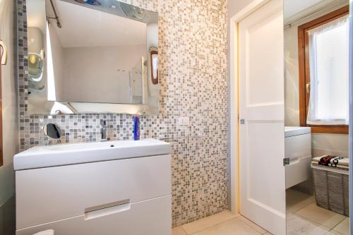 a white bathroom with a sink and a mirror at Manessy in Badesi