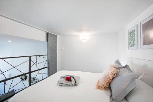 a bedroom with a bed with white sheets and pillows at Loft El Ramonal in Candelaria