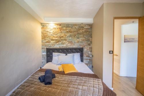 a bed in a room with a brick wall at Villa Solsticia in Albitreccia