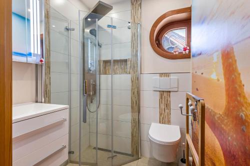 a bathroom with a toilet and a glass shower at Moin Moin in Friedrichskoog-Spitze