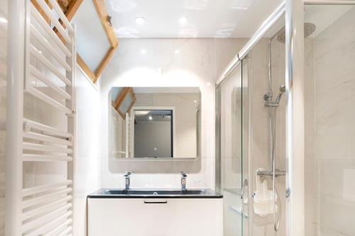 a bathroom with a sink and a mirror at Villa Patio Proche Plage in Seignosse