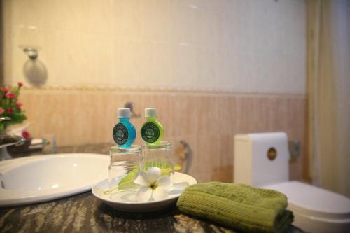 a bathroom with a sink and two bottles on a counter at Oasey Beach Hotel in Bentota