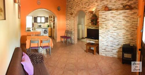 a living room with a table and a kitchen at Casas Da Lagoa - T2 Norte in Aldeia de Brescos