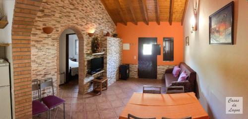 a living room with a couch and a tv in a room at Casas Da Lagoa - T2 Norte in Aldeia de Brescos