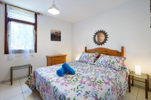 a bedroom with a bed with a blue stuffed animal on it at Bungamerica272 in Playa de las Americas