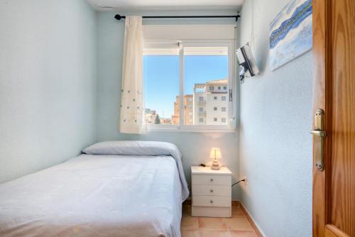 a small bedroom with a bed and a window at Oliva Avinyo in Oliva