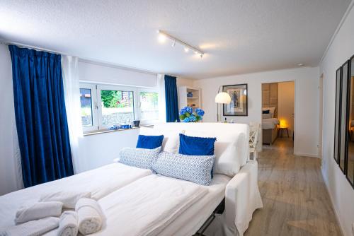 a bedroom with a large white bed with blue pillows at Royal Delft Boutique Apartment in Dinslaken