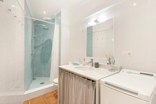 a white bathroom with a sink and a shower at Casa Limón in Vélez-Málaga