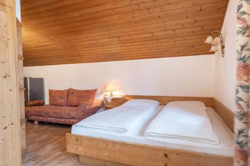 a bedroom with a bed and a couch at Residence Kronstein - Fewo 7 in Tesimo