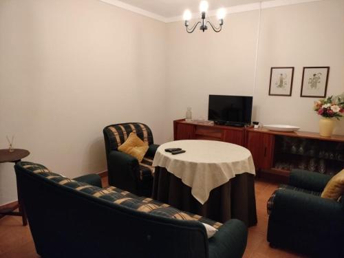 a living room with a table and chairs at Casa da Avó Cândida in Granja