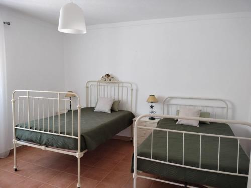 two beds in a room with white walls at Casa da Avó Cândida in Granja