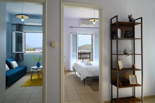 a living room with a bed and a room with a mirror at Elounda Luso Apartment in Elounda