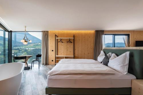 a bedroom with a large bed and a table at Aumia Apartment Diamant in Völs am Schlern