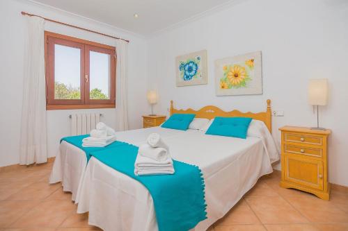 a bedroom with a large bed with towels on it at Finca Can Cocou in Can Picafort