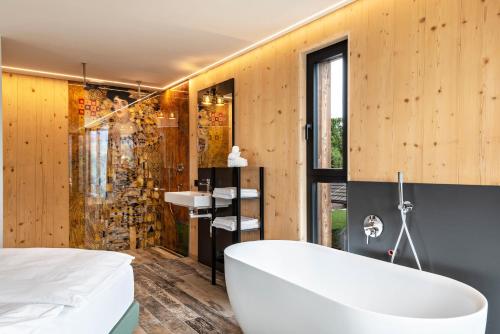 a bathroom with a tub and a shower and a sink at Aumia Apartment Diamant in Völs am Schlern