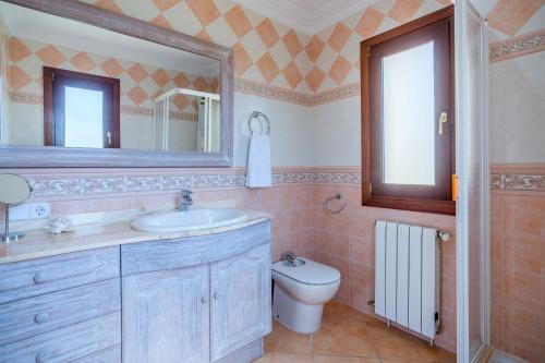 a bathroom with a sink and a toilet and a mirror at Finca Can Cocou in Can Picafort