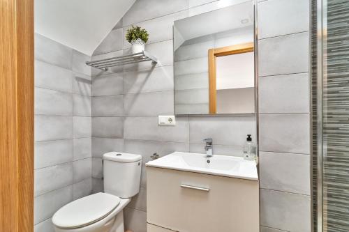 a white bathroom with a toilet and a sink at Almijarahouse in Nerja
