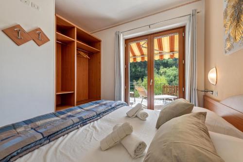 a bedroom with a bed and a large window at Residence Tatiana A1 in Tremosine Sul Garda