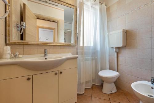 a bathroom with a sink and a toilet and a mirror at Residence Tatiana A1 in Tremosine Sul Garda
