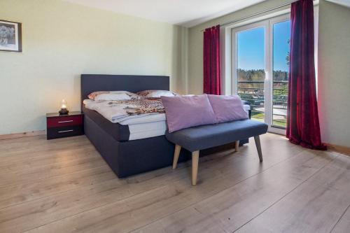 a bedroom with a bed and a chair and a window at Ferienwohnung Waldidyll in Wolgast