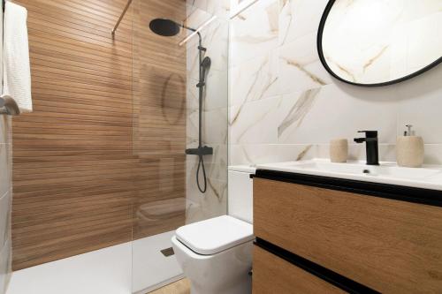 a bathroom with a toilet and a sink and a mirror at Oasis Pool View in Maspalomas