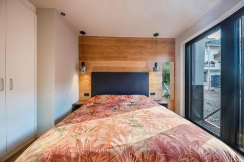 a bedroom with a bed and a large window at Apartment 16 cityview in Cornedo all'Isarco