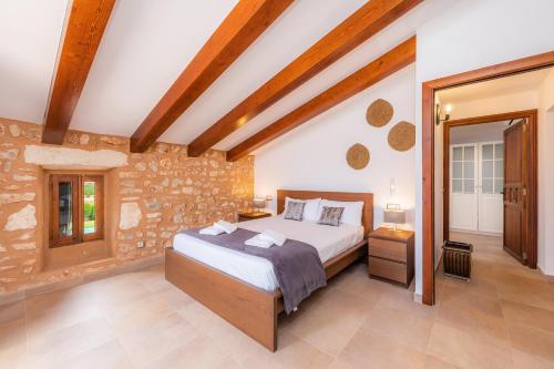 a bedroom with a large bed and a stone wall at Sa Pleta in Manacor