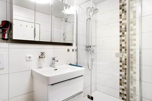 a white bathroom with a sink and a shower at Wanderglück in Missen-Wilhams