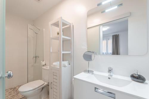 a bathroom with a toilet and a sink and a mirror at Ca sa Tia Lluisa in Santanyi