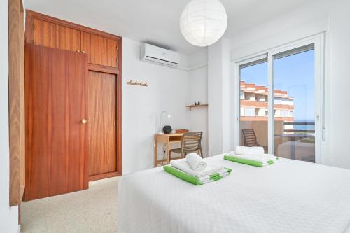 a white bedroom with two beds and a door at Casa Bellota in Torrox