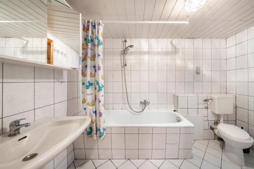 a bathroom with a tub and a toilet and a sink at Bungalow 41 - Kimbucht in Reichendorf