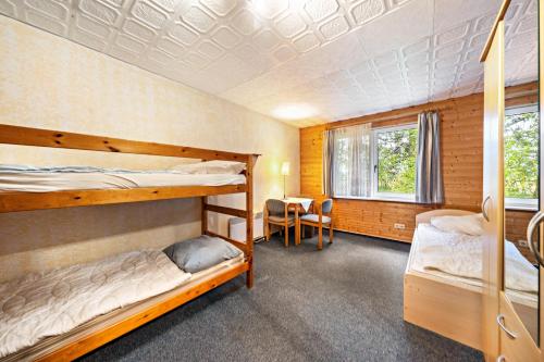 a bedroom with two bunk beds and a desk at Bungalow 41 - Kimbucht in Reichendorf
