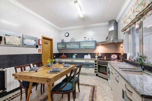 a large kitchen with a wooden table and chairs at Casa da Cidade de Loulé in Loulé