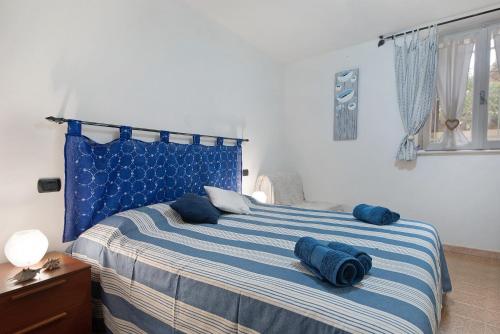 ein Schlafzimmer mit einem blauen Bett und Kissen darauf in der Unterkunft Casa Deiva in Deiva Marina