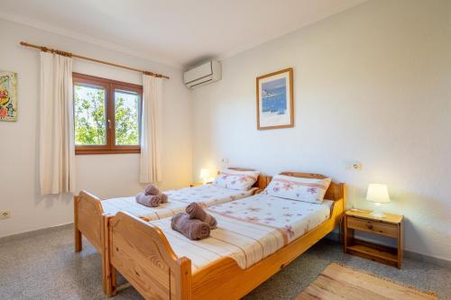 a bedroom with two beds and a window at Casa Mediterranea in Cala Santanyi
