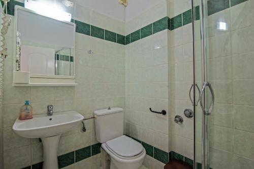 a bathroom with a toilet and a sink and a shower at Andromaches large apartment in Virós