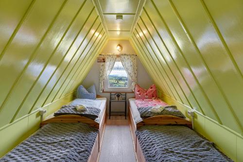 two beds in a small room with a window at Finnhütte Hohe Klinge Trusetal in Brotterode