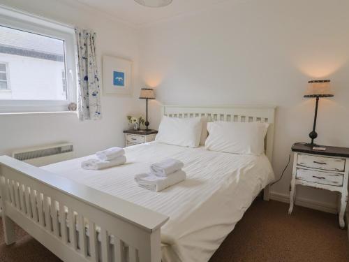 a bedroom with a large white bed with towels on it at 1 Bay View Court in Lyme Regis